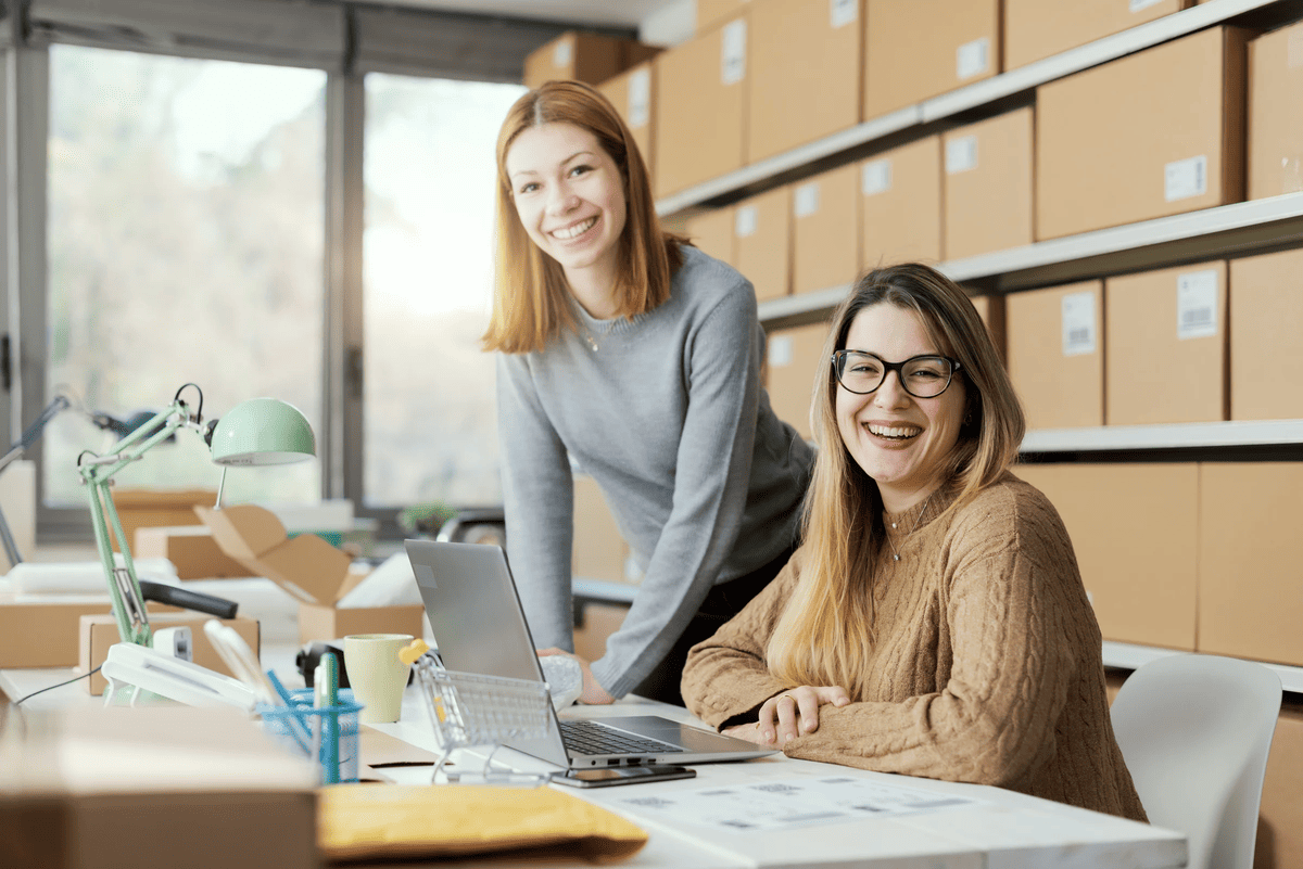 Young e-commerce business owners working together in the store, they are smiling at camera